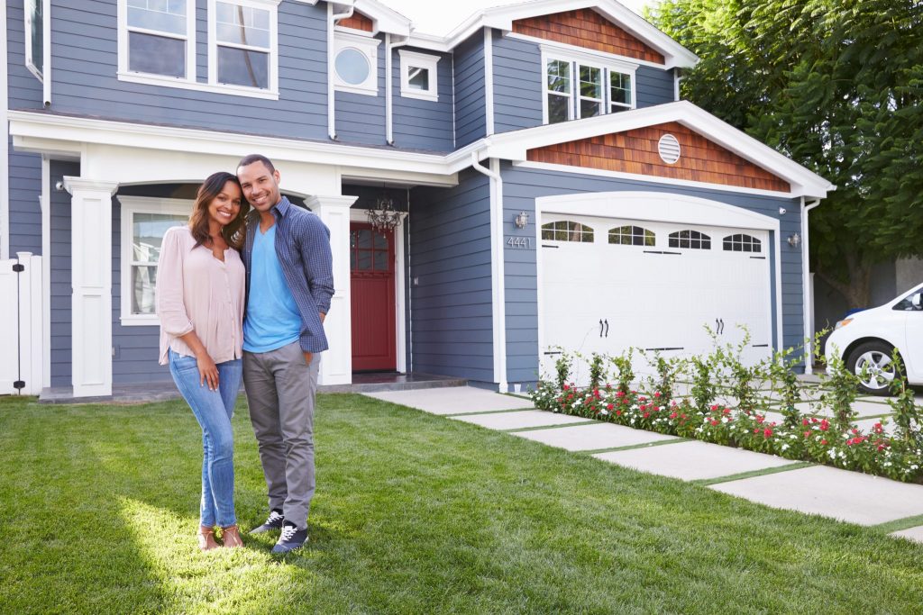 Couple in front of new home