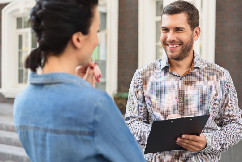 Man with Clipboard Smiling at Woman