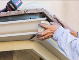 Man setting up Seamless Gutter Guard System