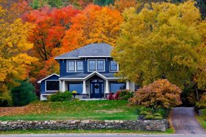 Blue house surrounded by fall foliage